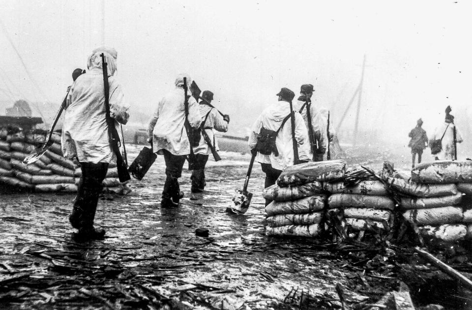 Finnish troops wearing their white tunics over their uniforms as camouflage in the snow covered country near the Mannerheim Line, go forward to reinforce the army facing the Russian forces, in southern Finland, Dec. 14, 1939.