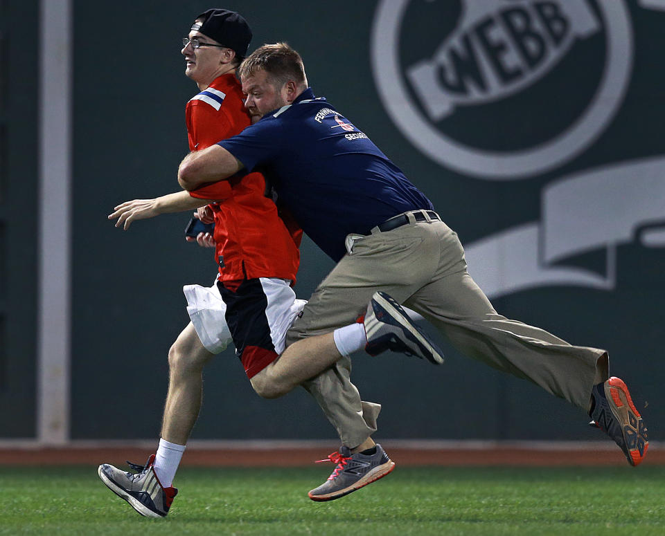 A fan stopped the game by running onto the field in the fifth inning, but he was quickly ran down and tackled by a member of the Fenway Park security team and taken away. The Boston Red Sox hosted the Kansas City Royals in a regular season MLB baseball game at Fenway Park in Boston, Aug. 28, 2016. (Photo by Jim Davis/The Boston Globe via Getty Images)