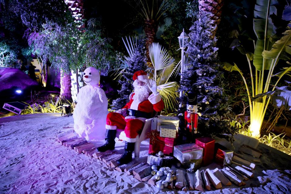 In this Friday, Dec. 20, 2013 photo, a man dressed as Santa Claus waits for guests to join him for a photograph during a Christmas party in Dubai, United Arab Emirates. The Middle East’s brashest city is increasingly embracing the trappings of Christmas in a way that would be unthinkable in more conservative parts of the Muslim world. Christmas trees adorn shopping centers and residential neighborhoods, and high-end hotels try to outdo one another with extravagant and boozy holiday dinners. (AP Photo/Kamran Jebreili)