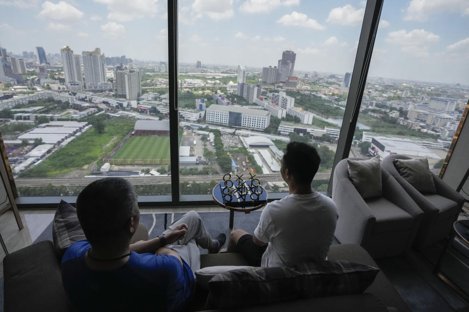 A gay Chinese couple watches the city view of Bangkok during a condominium tour in Bangkok, Thailand, Friday, Aug. 18, 2023. LGBTQ+ people from China who are frequently scorned and ostracized at home are coming to Thailand in droves. They're drawn by the freedom to be themselves. Bangkok is only a 5-hour flight from Beijing, and Thailand's tourism authorities actively promote its status as among the most open to LGBTQ+ people in the region.(AP Photo/Sakchai Lalit)