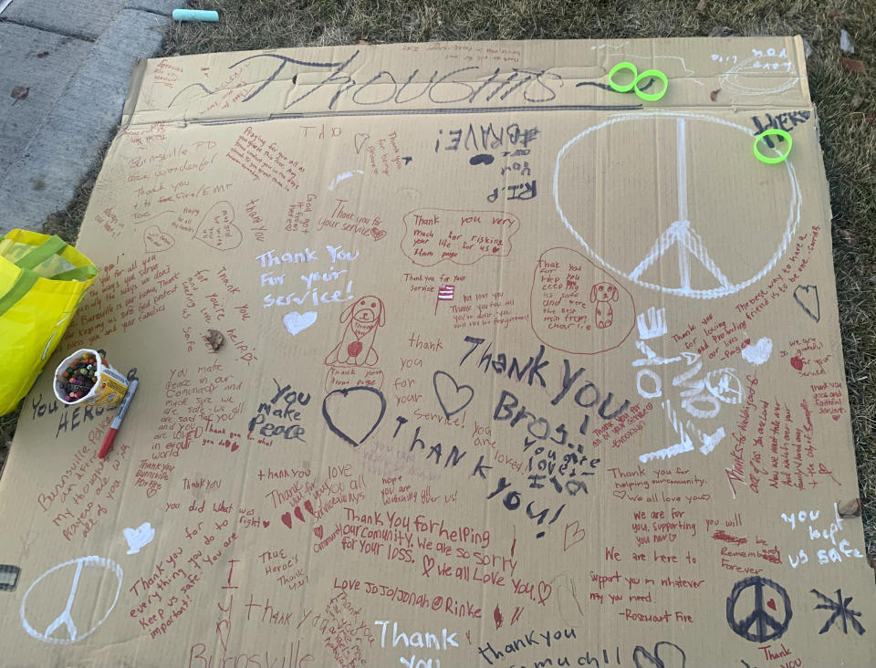 A poster sits the grass outside the Burnsville, Minn. police station, where people could leave handwritten messages, during a vigil, Tuesday, Feb. 20, 2024, for Burnsville Police Officers Paul Elmstrand and Matthew Ruge and Firefighter/Paramedic Adam Finseth, who were killed in the line of duty on Feb. 18, 2024. (Mara H. Gottfried/Pioneer Press via AP)