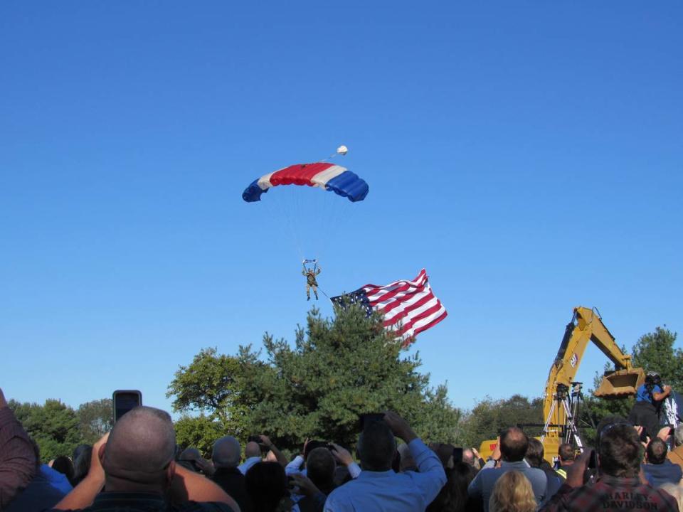 Retired Lt. Col. Bill Markham, flying the American flag, parachuted in to an event on Oct. 19, 2021 to break ground on the planned construction of a bourbon distillery in Somerset, Ky., by Horse Soldier Farms.