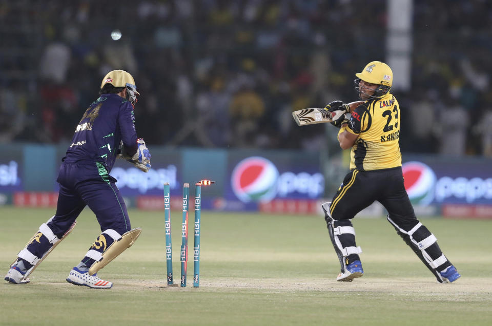 The bails fly off the wicket resulting in the dismissal of Peshawar Zalmi batsman Kamran Akmal, right, during the final cricket match of Pakistan Super League between Peshawar Zalmi and Quetta Gladiator at National stadium in Karachi, Pakistan, Sunday, March 17, 2019. (AP Photo/Fareed Khan)