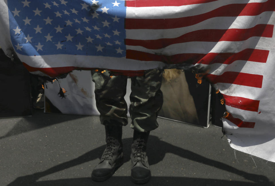 FILE - In this Friday, May 31, 2019 file photo, a demonstrator burns a representation of the U.S. flag during the annual Quds, or Jerusalem Day rally as the Trump administration tries to offer an Israeli-Palestinian peace plan. in Tehran, Iran. (AP Photo/Vahid Salemi, File)