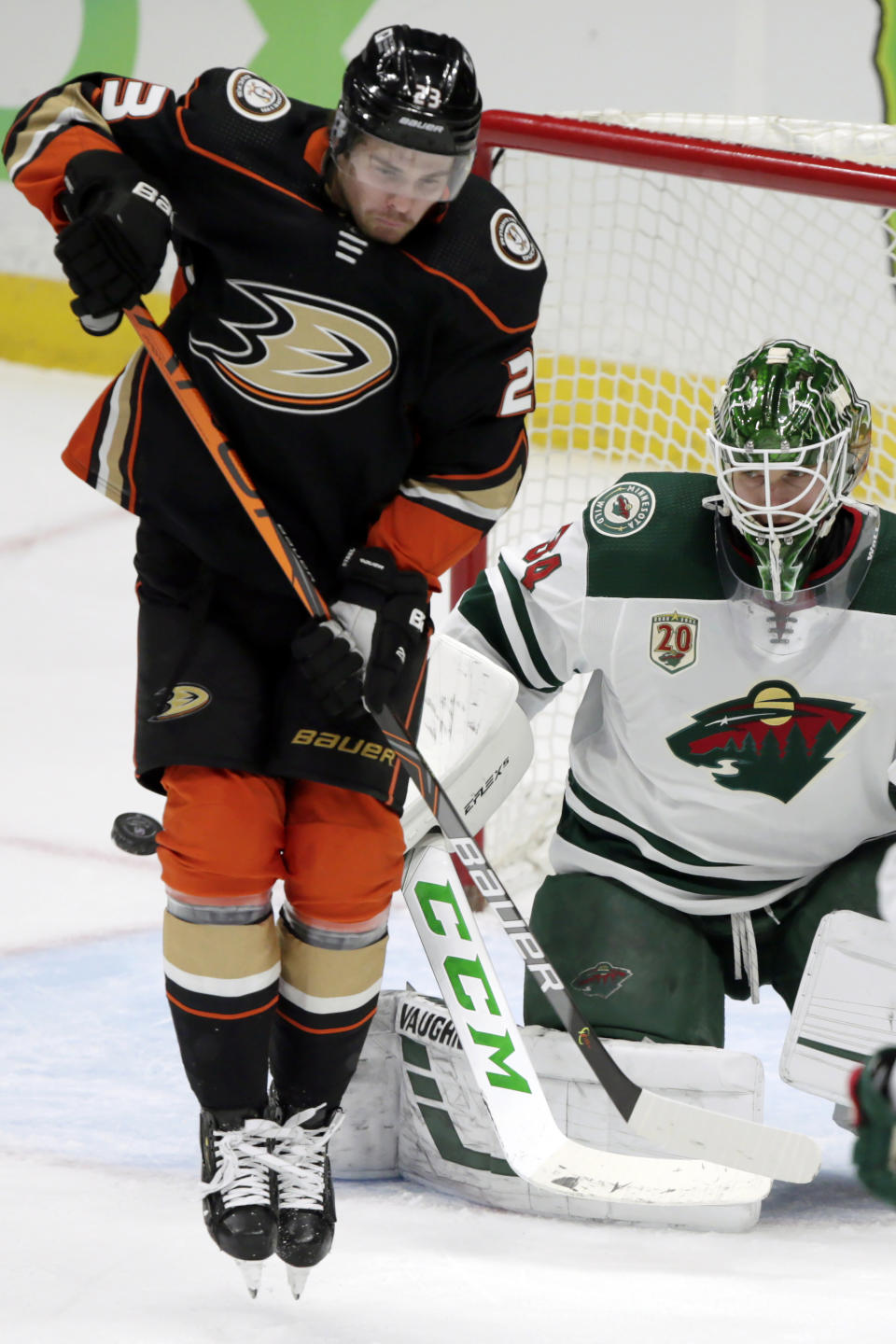 Anaheim Ducks center Sam Steel, left, shields Minnesota Wild goaltender Kaapo Kahkonen as the puck sails wide of the goal during the first period of an NHL hockey game in Anaheim, Calif., Wednesday, Jan. 20, 2021. (AP Photo/Alex Gallardo)