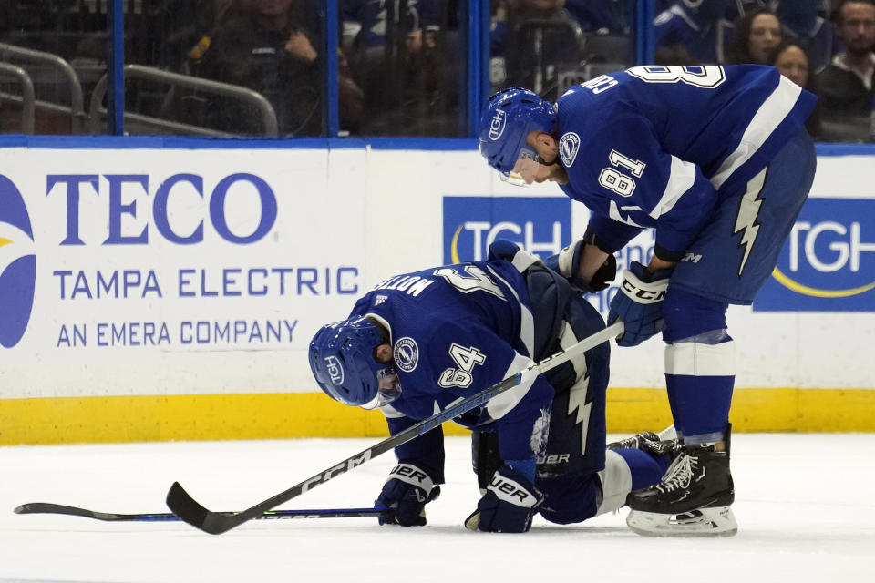 Tampa Bay Lightning center Tyler Motte (64) is helped off the ice by defenseman Erik Cernak (81) after blocking a shot by the Ottawa Senators during the second period of an NHL hockey game Thursday, April 11, 2024, in Tampa, Fla. (AP Photo/Chris O'Meara)