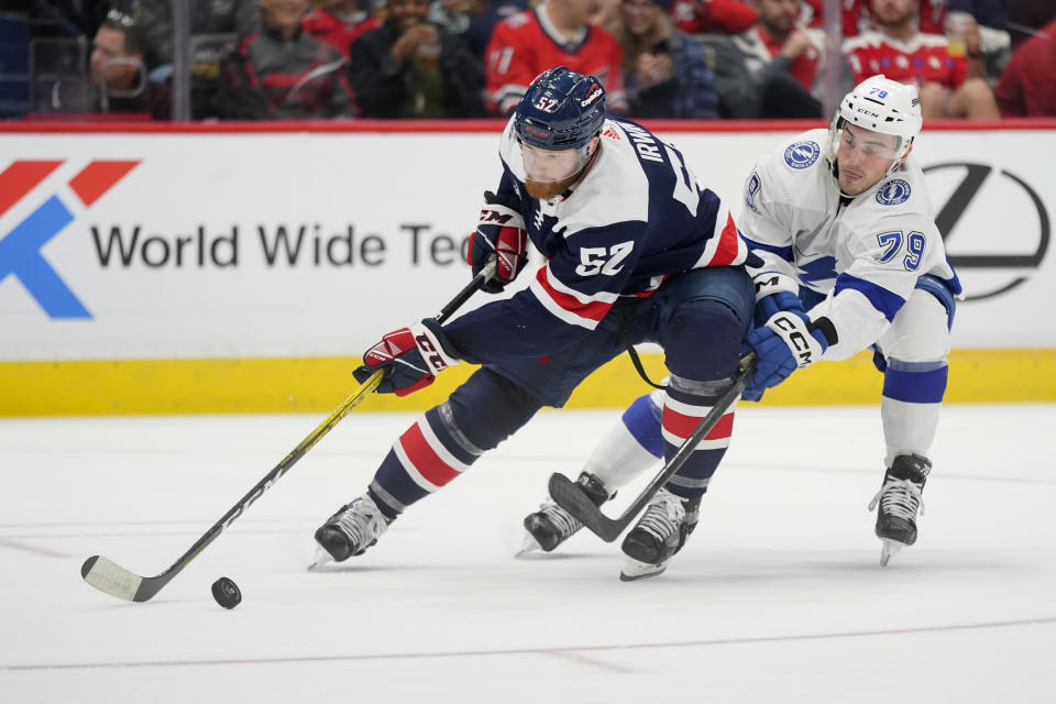 Washington Capitals defenseman Matt Irwin skates past Tampa Bay Lightning center Ross Colton in the second period of an NHL hockey game, Friday, Nov. 11, 2022, in Washington. (AP Photo/Patrick Semansky)