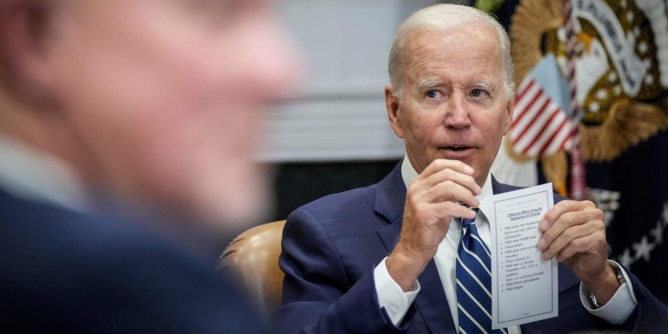 President Joe Biden, background, holding a cue card at a meeting with leaders on offshore wind energy on June 23, 2022