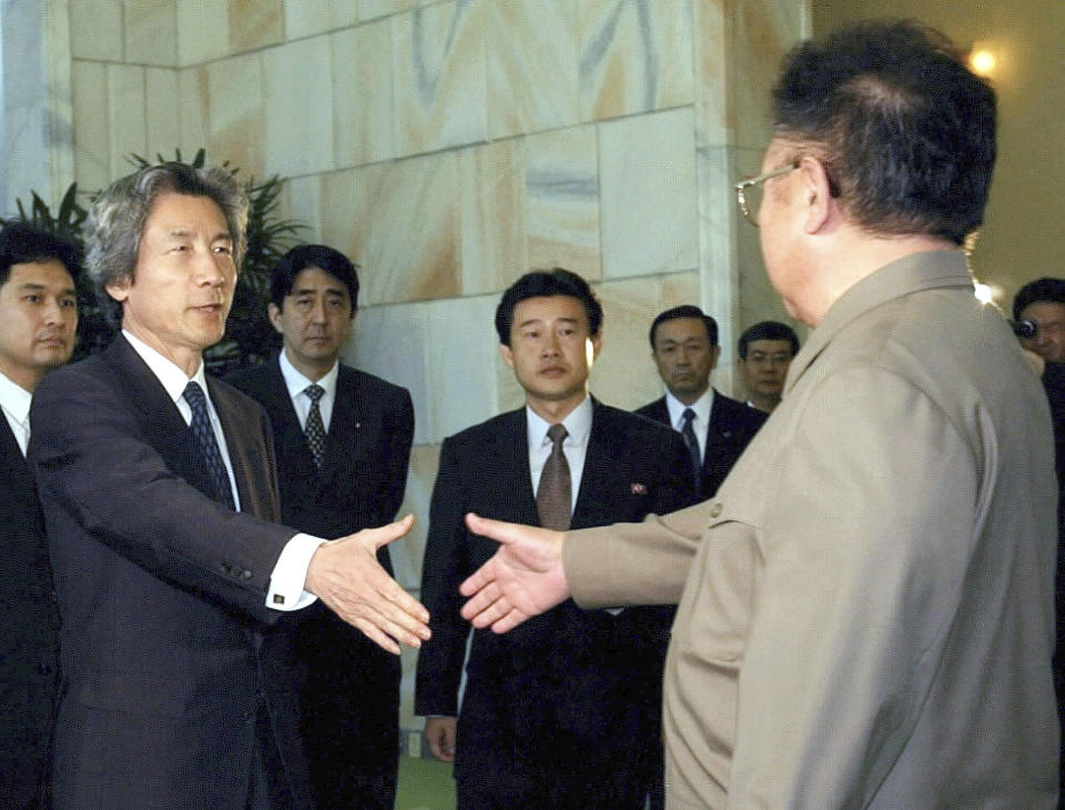 FILE - North Korean leader Kim Jong Il, right, shakes hands with Japanese Prime Minister Junichiro Koizumi, second left, prior to their summit talks in Pyongyang, North Korea on Sept. 17, 2002. Then Deputy Chief Cabinet Secretary Shinzo Abe is pictured at third left. In 2005, Abe was appointed chief cabinet secretary under Prime Minister Junichiro Koizumi, during which he leads negotiations to return Japanese citizens abducted to North Korea. (Kyodo News via AP)