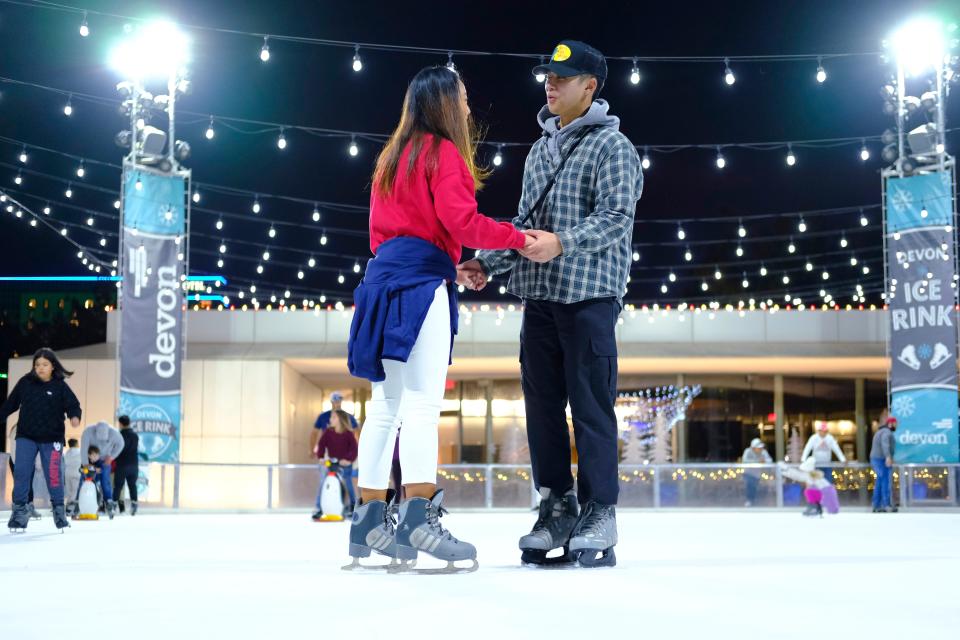 Meagan Li, left, and Jia Mok enjoy the moderate weather on opening weekend of skating at the Devon Ice Rink in the Myriad Gardens, a part of Downtown in December, Saturday, November 20, 2021.