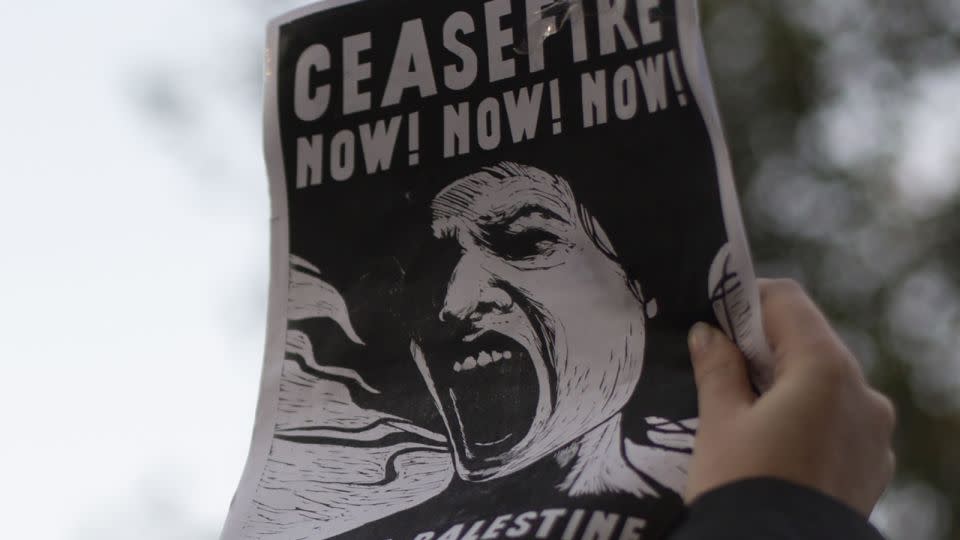 A demonstrator holds a sign calling for a ceasefire during Friday's demonstration. - Laura Oliverio/CNN