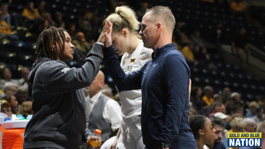 Mark Kellogg (right) high-fives injured senior guard Zya Nugent (left) during the first half of Kellogg’s first win as WVU head coach on Nov. 7, 2023. (Photo Ryan Decker, Gold and Blue Nation)