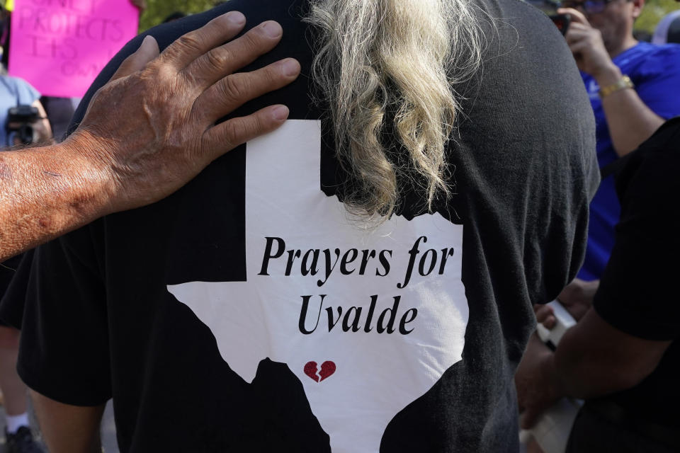 Vincent Salazar, grandfather of shooting victim Layla Salazar, has a supporting hand placed on his shoulder as he gives an interview at Robb Elementary prior to a protest march, Sunday, July 10, 2022, in Uvalde, Texas. Students who survived the May 24 shooting at an elementary school in Uvalde, Texas are spending the summer grappling with post-traumatic stress disorder. Meanwhile, parents find themselves unable to help them, worried the tragedy at Robb Elementary struck a largely Hispanic town as Latinos continue to face disparities to access mental health care. (AP Photo/Eric Gay)