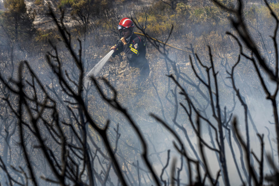 A firefighter in action during extinguishing works of a wildfire near Altura, eastern Spain, on Friday, Aug. 19, 2022. Up to early August, 43 large wildfires — those affecting at least 500 hectares (1,235 acres) — were recorded in the Mediterranean country by the Ministry for Ecological transition, while the average in previous years was 11. The European Forest Fire Information System estimates a burned surface of 284,764 hectares (704,000 acres) in Spain this year. That's four times higher than the average since records began in 2006. (AP Photo/Alberto Saiz)