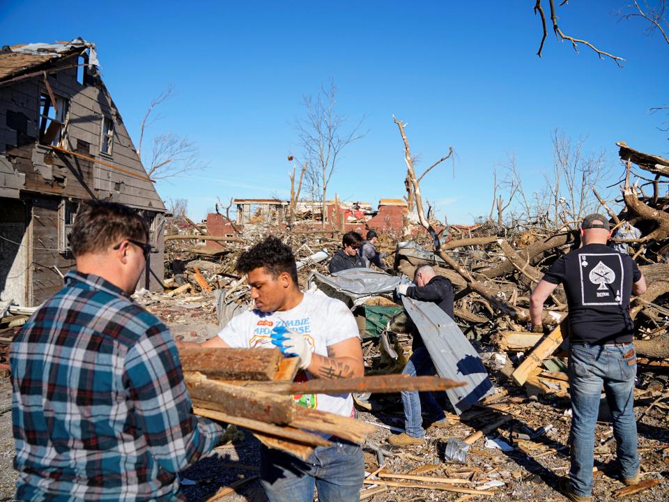 People clean up debris after a devastating outbreak of tornadoes ripped through several U.S. states, in Mayfield, Kentucky, U.S., December 12, 2021 (REUTERS)