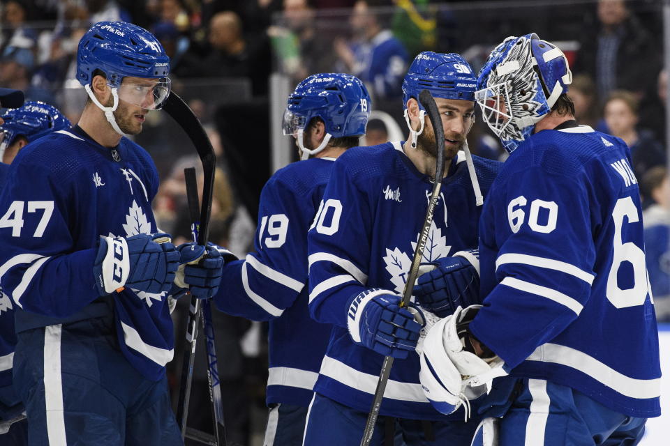 Toronto Maple Leafs forward Ryan O'Reilly (90) celebrates with goaltender Joseph Woll (60) and other teammates after they defeated the Montreal Canadiens in NHL hockey game action in Toronto, Saturday, Feb. 18, 2023. (Christopher Katsarov/The Canadian Press via AP)