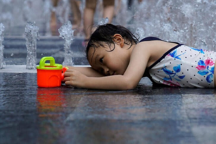 Imagen de archivo de una niña refrescándose en una fuente en medio de la ola de calor en Shanghái, China.