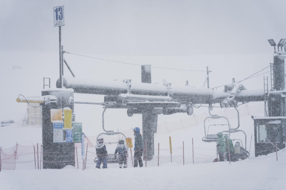 Snow falls as skiers wait for a lift on the Big Mountain Resort during a storm, Saturday, March 30, 2024, in Big Bear Lake, Calif. (Big Mountain Resort via AP)