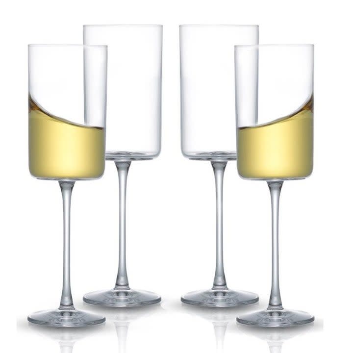 set of four square wine glasses with two half full of white wine