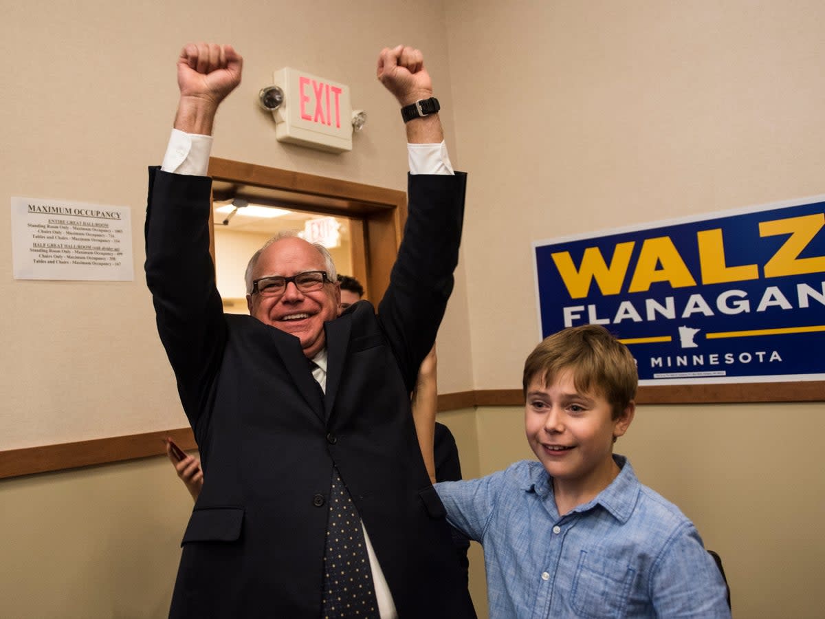 Tim Walz and his son Gus Walz celebrate while entering his election night party on August 14, 2018 in St Paul, Minnesota. He was re-elected as governor in 2022 (Getty Images)