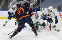 Edmonton Oilers' Connor McDavid (97) takes a shot on Vancouver Canucks goalie Braden Holtby (49) as Bo Horvat (53) defends during the second period of an NHL hockey game Wednesday, Jan. 13, 2021, in Edmonton, Alberta. (Dale MacMillan/The Canadian Press via AP)