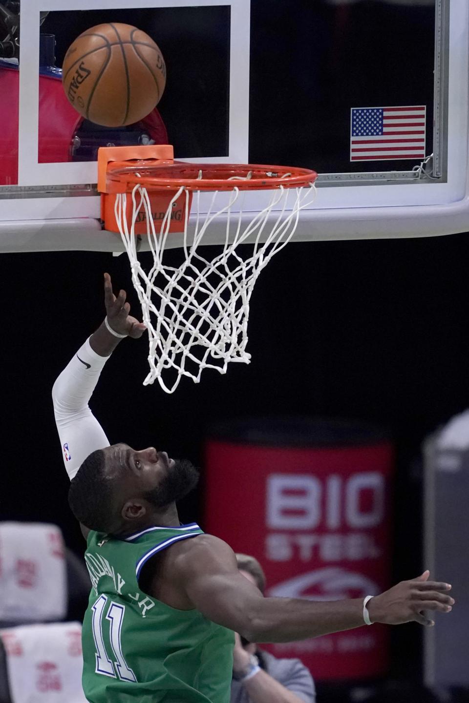 Dallas Mavericks' Tim Hardaway Jr. (11) looks up as his shot falls for a score in the first half of an NBA basketball game against the Memphis Grizzlies in Dallas, Monday, Feb. 22, 2021. (AP Photo/Tony Gutierrez)