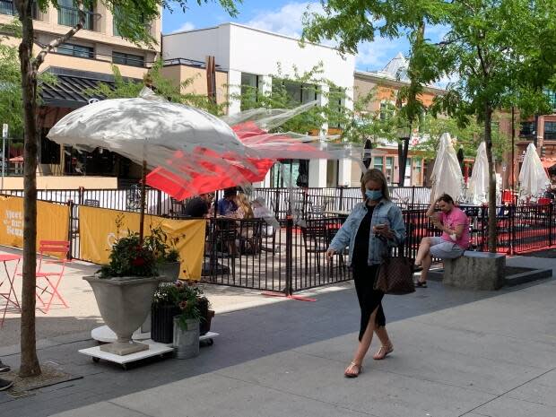 A pedestrian walks down Bernard Avenue in downtown Kelowna, B.C. (Winston Szeto/CBC - image credit)