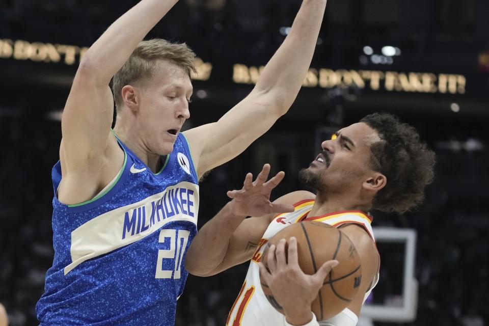 Milwaukee Bucks' AJ Green fouls Atlanta Hawks' Trae Young during the first half of an NBA basketball game Saturday, Dec. 2, 2023, in Milwaukee. (AP Photo/Morry Gash)