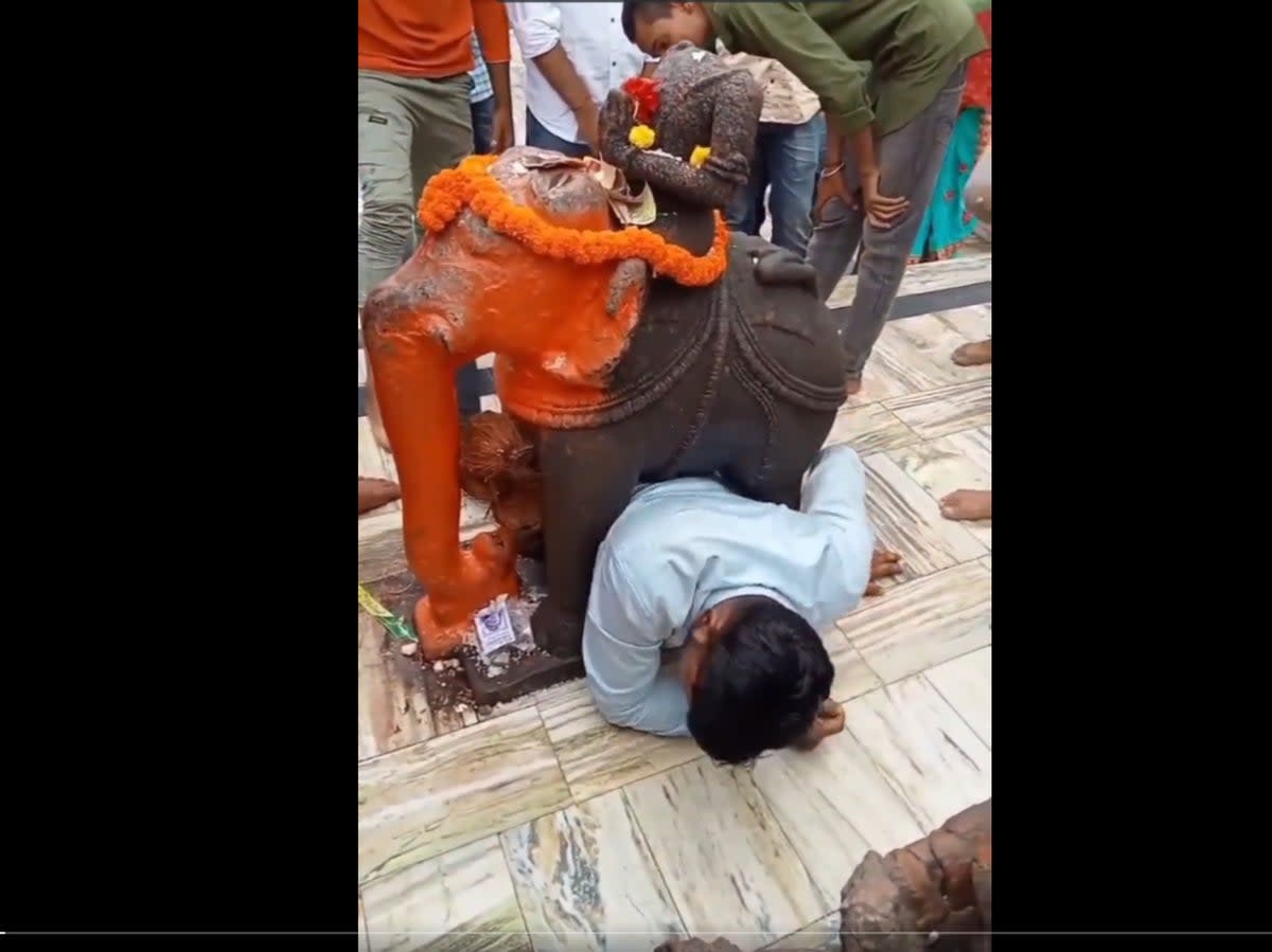 A video of a man in India who got stuck under an elephant statue in a temple has gone viral  (@nkk_123 / Twitter)