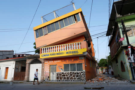 A man walks next to a building which was damaged in an earthquake that struck the southern coast of Mexico late on Thursday, in Juchitan, Mexico, September 9, 2017. REUTERS/Carlos Jasso