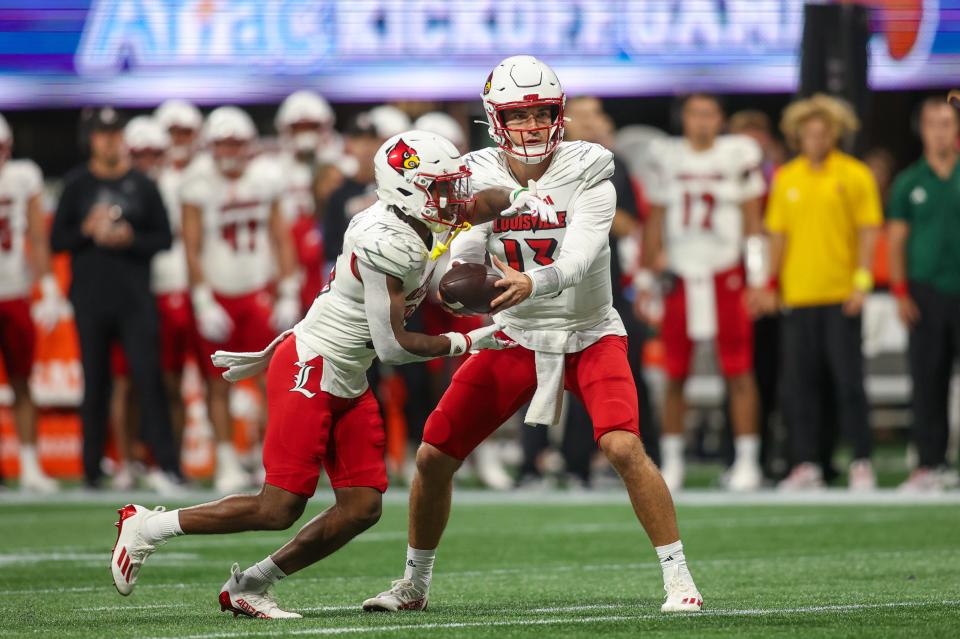 Louisville quarterback Jack Plummer hands the ball to running back Jawhar Jordan in Friday's win over Georgia Tech. The run game was key for the Cardinals in the victory.