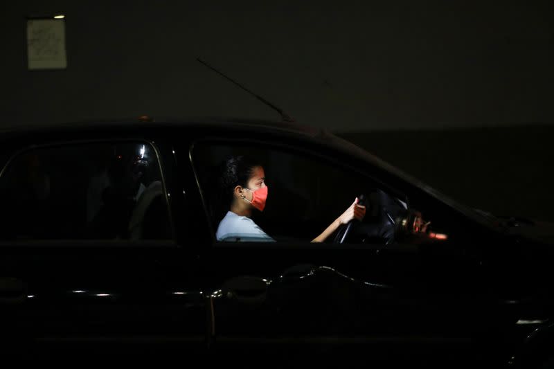 Doctor Maria Martinez, 24, drives her car in a queue to get fuel at a gas station during a nationwide quarantine due to the coronavirus disease (COVID-19) outbreak, in Caracas