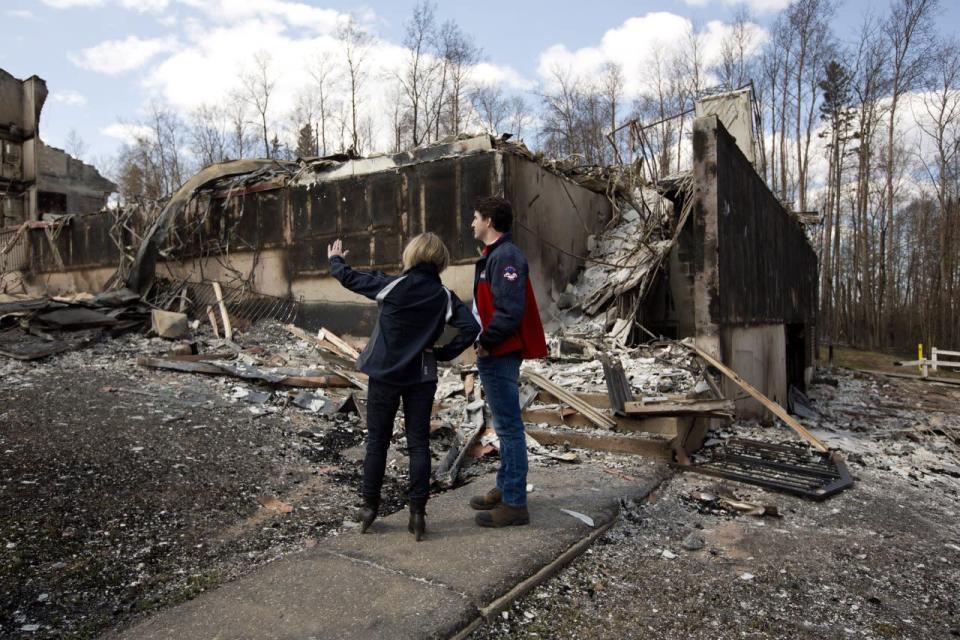 Prime Minister Justin Trudeau, right, and Alberta Premier Rachel Notley look over the devastation during a visit to Fort McMurray, Alta., on Friday, May 13, 2016. THE CANADIAN PRESS/Jason Franson