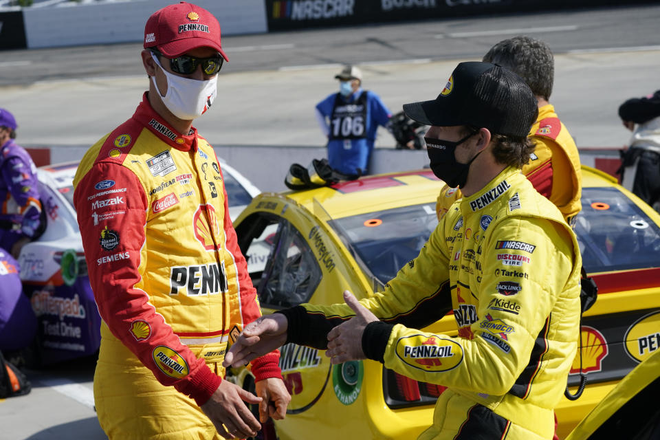 Joey Logano, left, and Ryan Blaney, right talk on pit row prior to the start of the NASCAR Cup Series auto race at Martinsville Speedway in Martinsville, Va., Sunday, April 11, 2021. (AP Photo/Steve Helber)