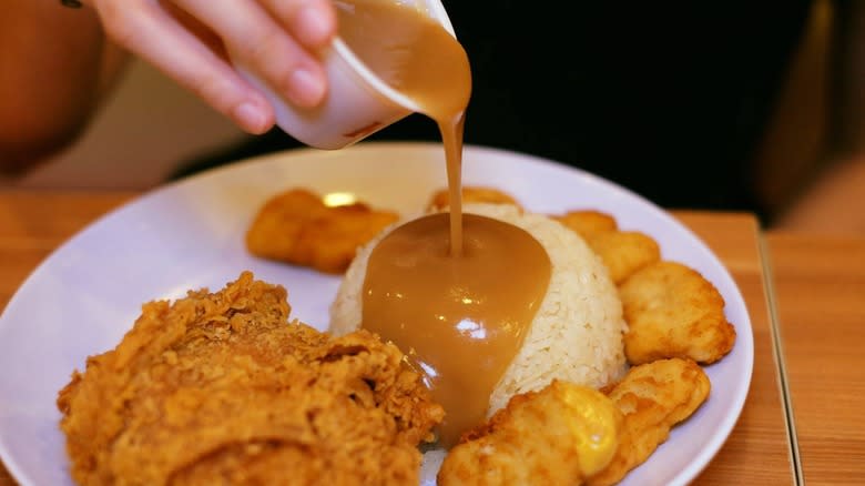 KFC gravy being poured over meal 