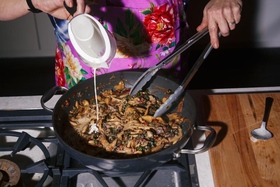 Cream is drizzled into a skillet.