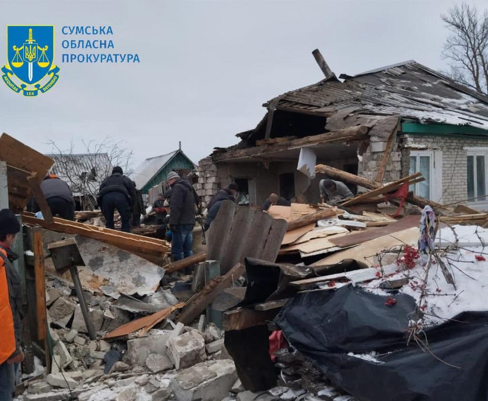 People standing on the rubbles of a destroyed house following Russian shelling, in Seredyna-Buda (UKRAINIAN PROSECUTOR OFFICE IN T)