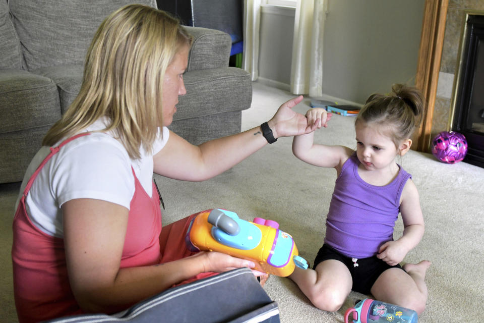 Early Intervention speech pathologist Megan Sanders works with 2-year-old Aria Faulkner at parents Lindsey and Kendrick Faulkner's home in Peoria, Ill., Aug. 15, 2023. (AP Photo/Ron Johnson)