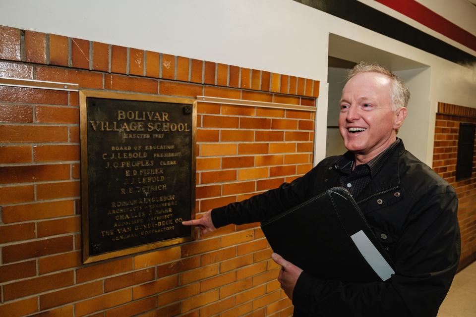 Mark Murphy talks about a historic plaque while giving a tour of the old Bolivar School, in Bolivar.
