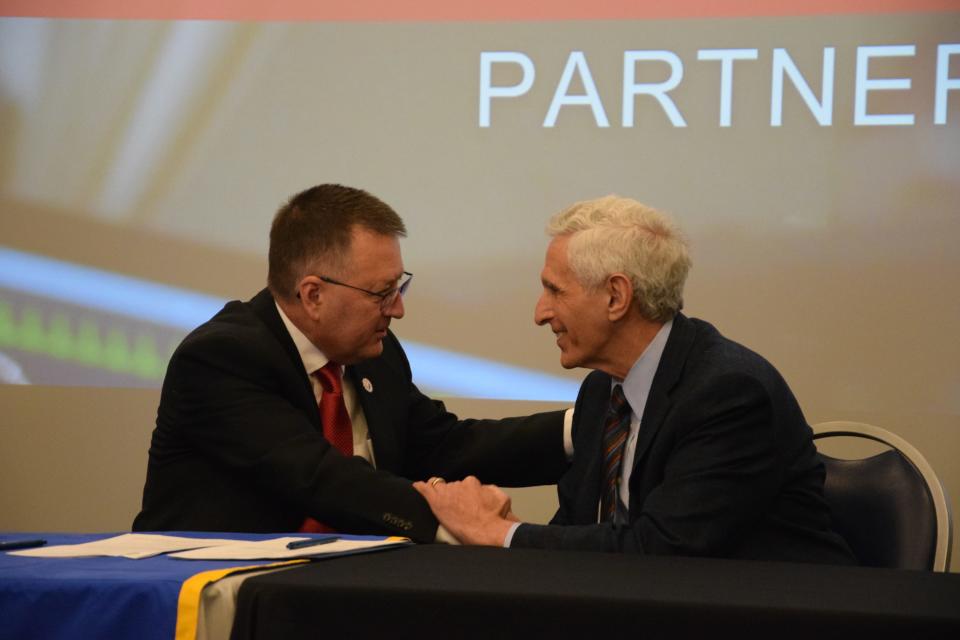 NCMC President David Roland Finley (left) and Davenport University President Richard Pappas shake hands after signing an agreement allowing for an easy transfer of credits for NCMC nursing graduates.