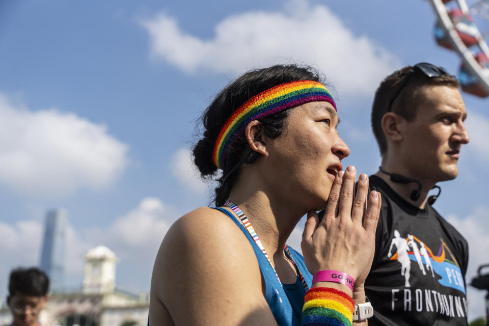 A participant wears rainbow bands at the AIDS Quilt Memorial Ceremony, ahead of the Gay Games in Hong Kong, Saturday, Nov. 4, 2023. The first Gay Games in Asia are fostering hopes for wider LGBTQ+ inclusion in the regional financial hub, following recent court wins in favor of equality for same-sex couples and transgender people. (AP Photo/Chan Long Hei)