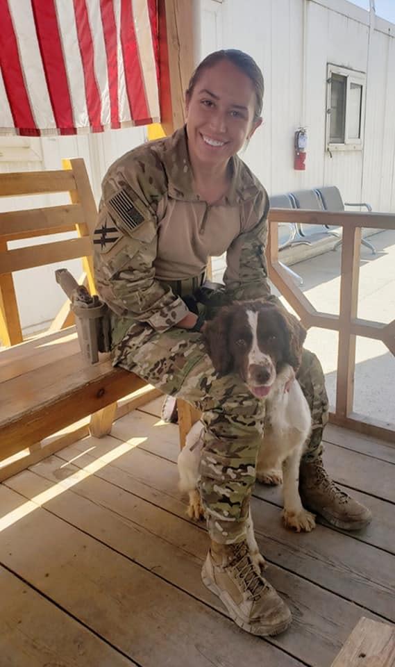 St. Pierre petting Chase, a military bomb-sniffing dog, while taking a break in Afghanistan. / Credit: Photo courtesy of Kristen St. Pierre