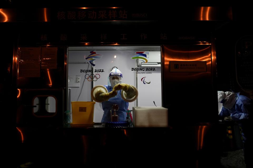 A worker prepares to administer a COVID-19 test at the 2022 Winter Olympics, Wednesday, Feb. 2, 2022, in Beijing. (AP Photo/Natacha Pisarenko)