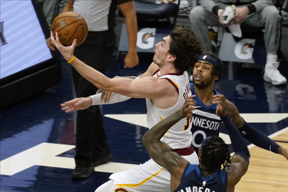 Cleveland Cavaliers' Cedi Osman, left, lays up in front of Minnesota Timberwolves' Jarred Vanderbilt, lower right, and D'Angelo Russell in the first half of an NBA basketball game Sunday, Jan. 31, 2021, in Minneapolis. (AP Photo/Jim Mone)