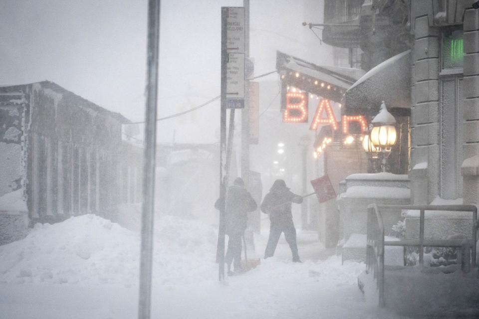 FILE - Workers shovel snow from their neighborhood restaurant and bar entrance in midtown Manhattan during a snowstorm, Feb. 1, 2021, in New York. Since the start of winter in December 2022, there has not been any measurable snowfall in New York City, meaning at least one-tenth of an inch accumulating on the ground, according to the National Weather Service. (AP Photo/Wong Maye-E, File)