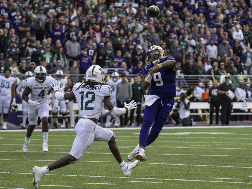 Washington quarterback Michael Penix Jr., right, throws a touchdown pass against Michigan State defensive back Chester Kimbrough during the first half of an NCAA college football game, Saturday, Sept. 17, 2022, in Seattle. (AP Photo/Stephen Brashear)