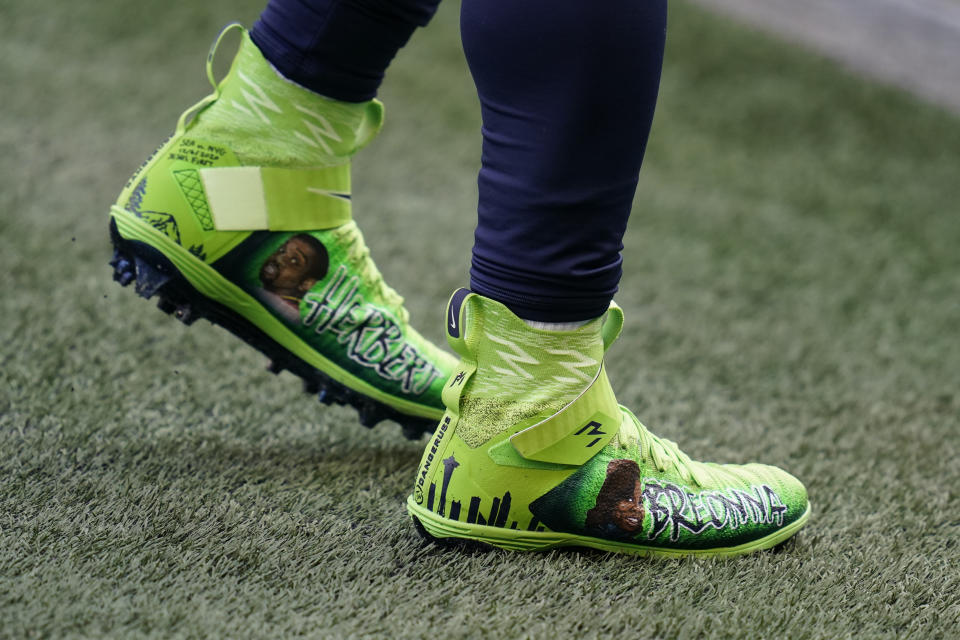 Seattle Seahawks quarterback Russell Wilson wears custom cleats with the name of Bronna Taylor and other victims of police brutality in support of Black Lives Matter as he warms up for an NFL football game against the New York Giants, Sunday, Dec. 6, 2020, in Seattle. (AP Photo/Elaine Thompson)