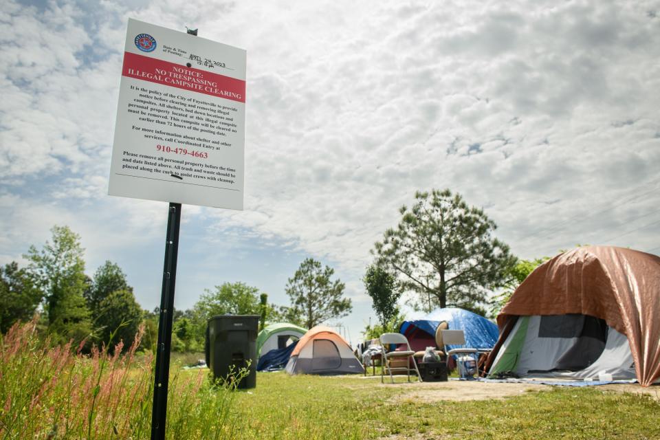A sign from the city of Fayetteville, N.C., is posted at a homeless encampment at Gillespie Street and Martin Luther King Jr. Freeway. The sign states that the encampment will be cleared in the near future.