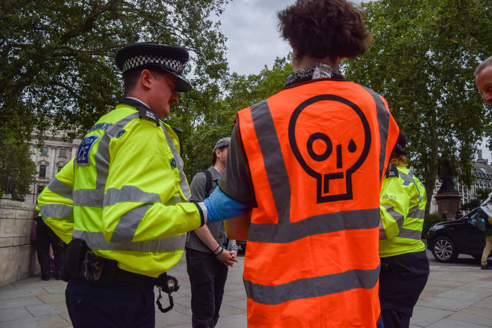 LONDON, UNITED KINGDOM - 2023/07/19: A police officer arrests a Just Stop Oil activist during the demonstration. The climate group staged their biggest protest yet with a series of back-to-back slow marches in Parliament Square, demanding that the government stops issuing new fossil fuel licences. Dozens of activists were arrested throughout the morning. (Photo by Vuk Valcic/SOPA Images/LightRocket via Getty Images)