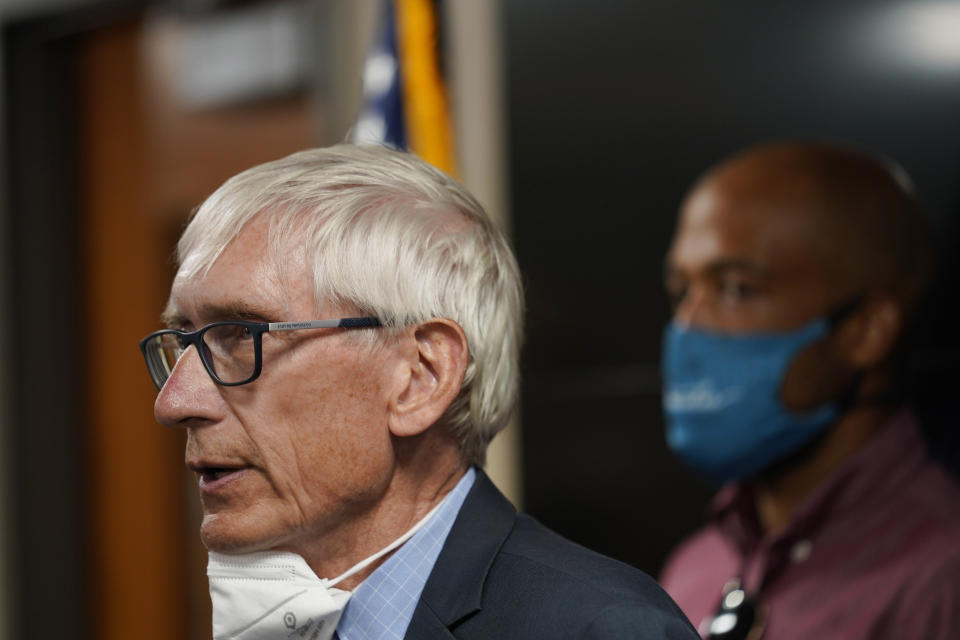 Wisconsin Governor Tony Evers speaks during a news conference Thursday, Aug. 27, 2020, in Kenosha, Wis. The city has suffered from unrest in the wake of the police shooting of Jacob Blake. Lt. Gov. Mandela Barnes is at rear. (AP Photo/Morry Gash)